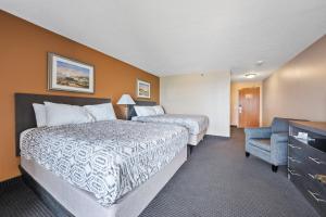 a hotel room with two beds and a chair at Bayshore Resort at Put-in-Bay in Put-in-Bay