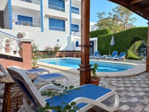 a patio with chairs and a swimming pool at Villa Kaslan Apartments in Luxor