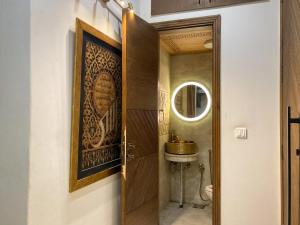 a bathroom with a wooden door and a sink at Homey Stays - 3 Bedroom Holiday Home - DHA in Lahore