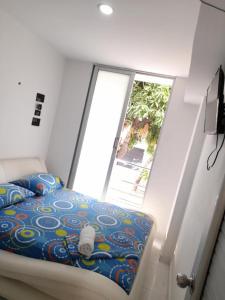 a bed in a room with a large window at Hotel URUMITA MAGICA in Valledupar