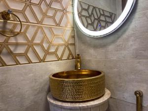 a bathroom with a gold sink on a counter at Homey Stays - 3 Bedroom Holiday Home - DHA in Lahore