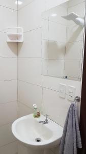 a white bathroom with a sink and a mirror at España Confort 2 in Ciudad del Este