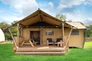 een prieel met een tafel en stoelen in het gras bij Camping les Campagnes in Rocamadour