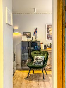 uma sala de estar com uma cadeira verde e uma prateleira em Enjoy Reykjavík Yellow Door Apartment em Reykjavík