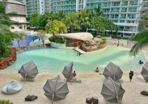 a swimming pool with umbrellas and people in the water at Azure Staycation in Manila