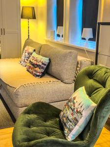 ein Wohnzimmer mit einem Sofa und einem Stuhl in der Unterkunft Enjoy Reykjavík Yellow Door Apartment in Reykjavík