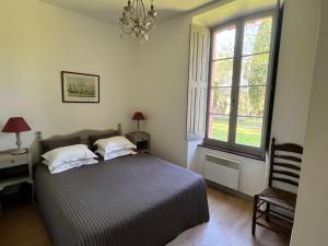 a bedroom with a bed and a window at Pavillon de Villefrancou in Montlaur