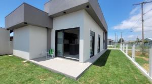 a white house with a green lawn at Casa Mar Dom Pedro in Arroio do Sal +31 photos