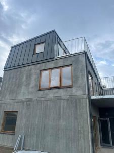 a building with a balcony on top of it at Nybyggd lgh 100m till stranden, 150m till golfbana ,samt gemensam pool och spa in Beddinge