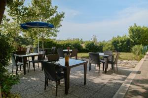 a patio with tables and chairs and an umbrella at Villa Marianna in Vasto