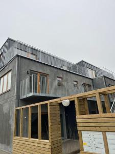 a building with a balcony on the side of it at Nybyggd lgh 100m till stranden, 150m till golfbana ,samt gemensam pool och spa in Beddinge