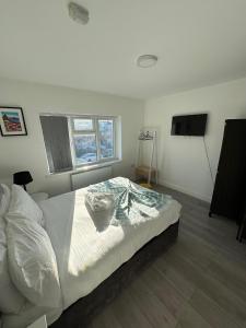 1 dormitorio con 1 cama blanca y TV de pantalla plana en Large 7 Bedrooms split-level Flat Sleeps up to 14 en Birmingham