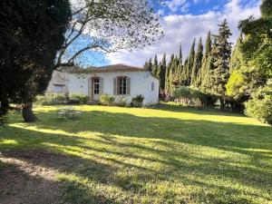 MontlaurにあるPavillon de Villefrancouの木々と芝生の庭の白い家