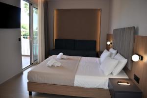 a bedroom with a large bed with a large window at Eden Beach Hotel in Agia Marina Nea Kydonias