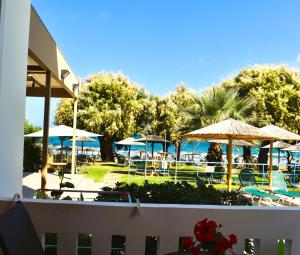 ein Resort mit Tischen und Sonnenschirmen und einem Pool in der Unterkunft Eden Beach Hotel in Agia Marina