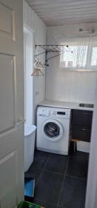 uma lavandaria com uma máquina de lavar roupa e uma janela em Berghof em Geysir