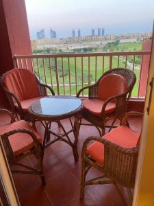 uma varanda com cadeiras e uma mesa na varanda em Golf Porto Marina em El Alamein
