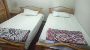 duas camas sentadas uma ao lado da outra num quarto em Golf Porto Marina em El Alamein