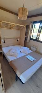 een slaapkamer met 2 bedden en een raam bij Camping les Campagnes in Rocamadour