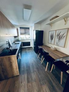 uma cozinha com uma mesa de madeira e um piso de madeira em Apartmán Opava s parkováním em Opava