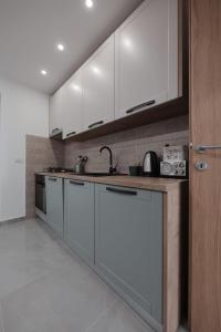 a kitchen with white cabinets and a sink at Apartmani Vinea Zara in Brčevec