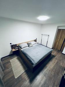 1 dormitorio con 1 cama y suelo de madera en Apartmán Opava s parkováním en Opava