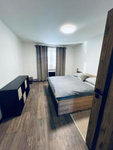 um quarto com uma cama e uma porta de madeira em Apartmán Opava s parkováním em Opava