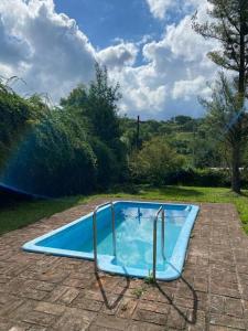 una piscina azul en la parte superior de un patio de ladrillo en TempoStay Raco en Las Tipas