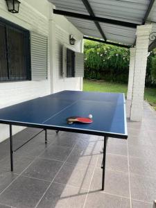 una mesa de ping pong azul con una pelota de tenis. en TempoStay Raco en Las Tipas