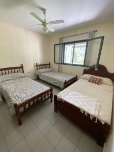 a bedroom with two beds and a ceiling fan at TempoStay Raco in Tipas