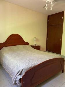 a bedroom with a large bed with a wooden headboard at TempoStay Raco in Tipas