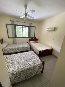 a bedroom with two beds and a ceiling fan at TempoStay Raco in Tipas