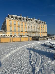 a large yellow building with snow in front of it at Wohnung Dachterrasse 3 in Brühl