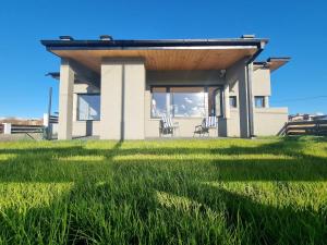 a house with a roof on a field of grass at Casita Sur Trevelin in Trevelin
