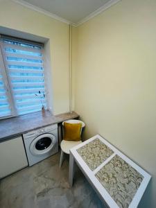 a laundry room with a washing machine and a table at Апартаменти поряд дорослої і дитячої лікарні біля Миколайчука, Орлика in Lviv