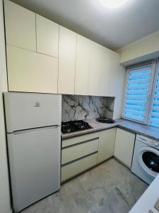 a white kitchen with a stove and a refrigerator at Апартаменти поряд дорослої і дитячої лікарні біля Миколайчука, Орлика in Lviv