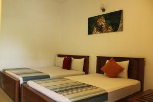 a room with two beds and a picture of a leopard at UD Garden Hotel in Kataragama