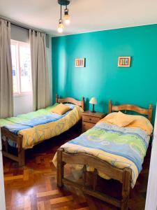 2 letti in una camera con pareti blu di Departamento Centrico a Mendoza