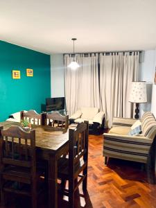 sala de estar con mesa, sillas y sofá en Departamento Centrico en Mendoza