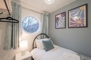 ein kleines Schlafzimmer mit einem Bett und einem Fenster in der Unterkunft Belfast City Centre + Parking by StayByNumbers. in Belfast