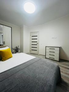 a bedroom with a large bed with a yellow pillow at Апартаменти поряд дорослої і дитячої лікарні біля Миколайчука, Орлика in Lviv