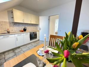a kitchen with a table with a vase of flowers at Ferien- & Monteurwohnung Schmidt in Schmalfeld in Schmalfeld