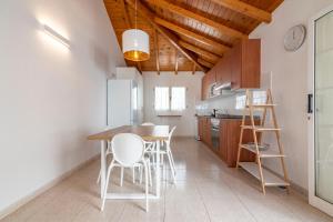 een keuken met een houten tafel en witte stoelen bij Casa Lina HolidayFV in Corralejo