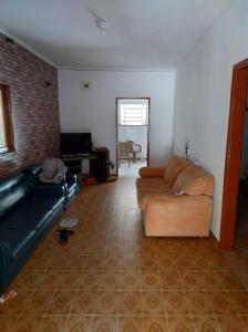 ein Wohnzimmer mit einem Sofa und einem TV in der Unterkunft Chacara lima in Pedro de Toledo