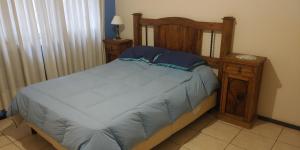 a bed with a wooden headboard and a night stand at Mendoza Centro 1 dormitorio in Mendoza