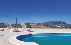 einen Pool mit zwei Stühlen und einem Zaun in der Unterkunft Las Cormenillas in Olvera