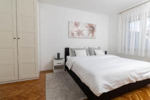 Un dormitorio blanco con una cama grande y una ventana en Golden day, en Vinkovci