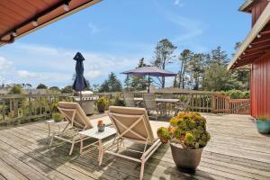 a deck with chairs and a table and an umbrella at Bodega Bay Inn in Bodega Bay