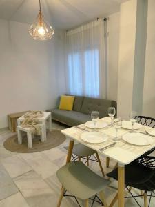 a living room with a table and chairs with wine glasses at Acogedor piso a un paso de Granada Capital. in Granada