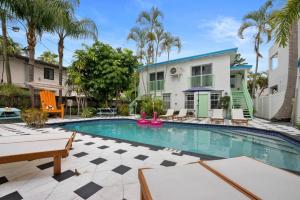 ein Pool vor einem Haus mit Palmen in der Unterkunft Las Olas Guest House in Fort Lauderdale
